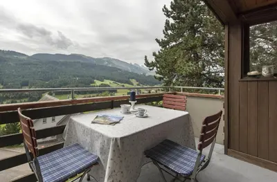a table and chairs on a balcony with a view at Chalet Ritornell in Wildhaus