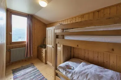 a bedroom with two bunk beds and a window at Chalet Ritornell in Wildhaus