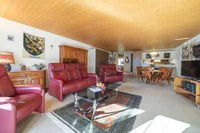 a living room with red leather furniture and a table at Haldenblick in Unterwasser