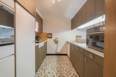 a kitchen with brown cabinets and a tile floor at Haldenblick in Unterwasser