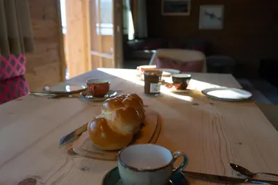 a table with a plate of bread and a cup of coffee at Chalet Hinterrugg in Wildhaus