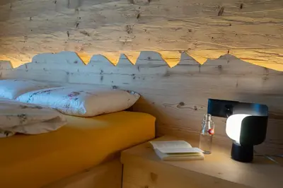 a bedroom with a bed and a desk with a lamp at Chalet Gamserrugg in Wildhaus