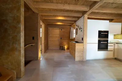 a large kitchen with wooden ceilings and a hallway at Chalet Chäserrugg in Wildhaus