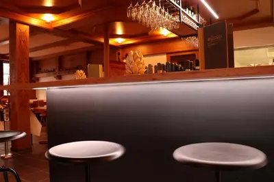 a bar with two stools in a restaurant at Hotel Restaurant Rössli in Alt Sankt Johann