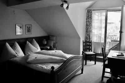 a bedroom with a bed and a desk and a window at Hotel Restaurant Rössli in Alt Sankt Johann