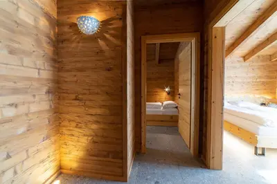 a wooden room with two beds and a mirror at Chalet Zuestoll in Wildhaus