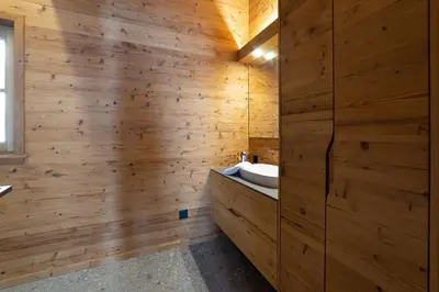 a bathroom with wooden walls and a sink at Chalet Zuestoll in Wildhaus