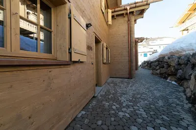 a building with a stone sidewalk next to a building at Chalet Zuestoll in Wildhaus