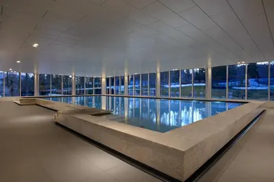 a large swimming pool in a building with windows at Oberwaid - Das Hotel. in St. Gallen