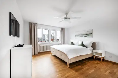 a white bedroom with a bed and a television at SOHO F !Gratis Parken, Free Parking! in Kreuzlingen