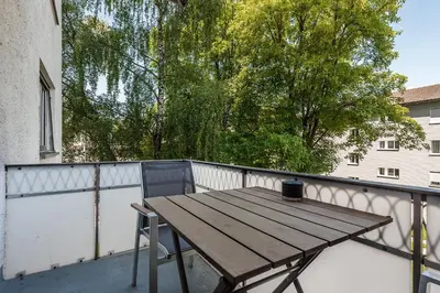 a wooden table and a chair on a balcony at SOHO 5B !Gratis Parken, Free Parking! in Kreuzlingen