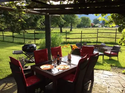 a wooden table with red chairs and a grill at BnB Haag in Haag