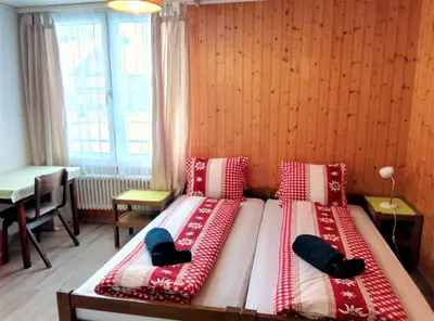 a bedroom with two beds with red and white pillows at Galluszentrum in Wildhaus
