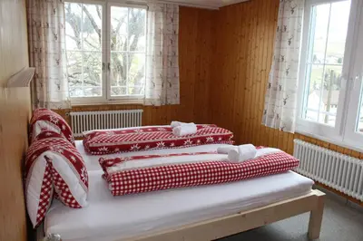 two beds in a room with red and white blankets at Galluszentrum in Wildhaus