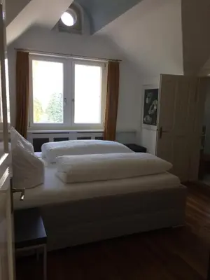 a large bed in a bedroom with a window at Schloss Brunnegg in Kreuzlingen