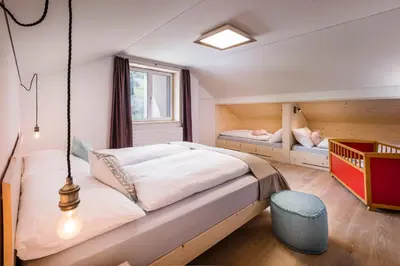 a bedroom with a bed and two bunk beds at Neuhof Gäste-& Schokohaus in Appenzell