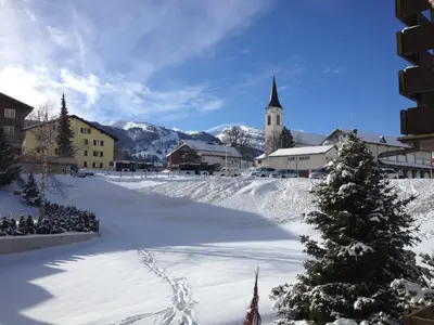 a snow covered town with a christmas tree and a church at Sonnastuba in Wildhaus