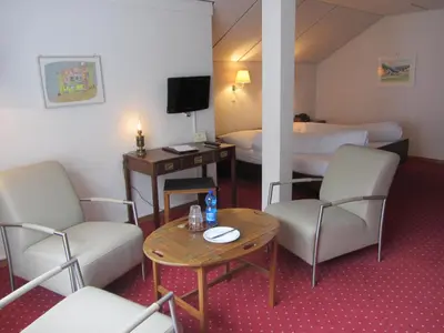 a hotel room with two beds and a table and chairs at Landhaus an der Thur in Alt Sankt Johann