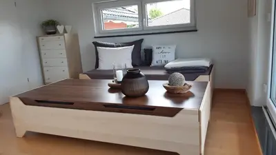 a coffee table in a room with a bed at Attika Ferienwohnung Merk in Kreuzlingen