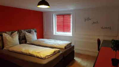 a bedroom with a bed and a window with a window blind at London Apartments in Rheineck