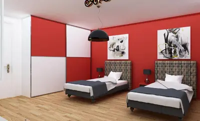 two beds in a room with red walls at London Apartments in Rheineck