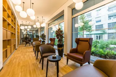 a waiting room with chairs and tables and windows at Giesserei in Arbon