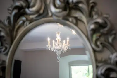 a chandelier in front of a mirror at Schloss Wartensee in Rorschacherberg