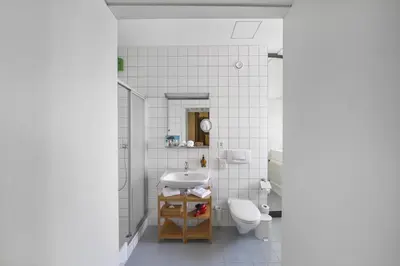 a white bathroom with a sink and a toilet at Schloss Wartensee in Rorschacherberg