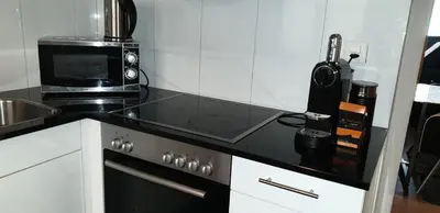 a kitchen with a black counter top with a microwave at Grosses Apartement 2 Schlafzimmer am Bodensee in Arbon