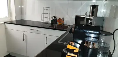 a kitchen with white cabinets and a black counter top at Grosses Apartement 2 Schlafzimmer am Bodensee in Arbon