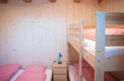 a bunk bed room with two bunk beds in it at Restaurant und Kaeserei Berghof in Ganterschwil