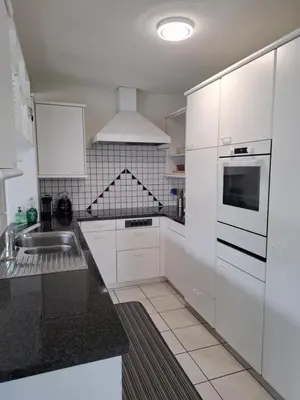 a white kitchen with white cabinets and a sink at Zwinglis Ferienwohnung in Nesslau