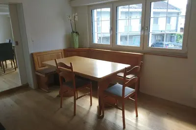 a dining room with a table and chairs and a window at Zwinglis Ferienwohnung Klärli in Nesslau