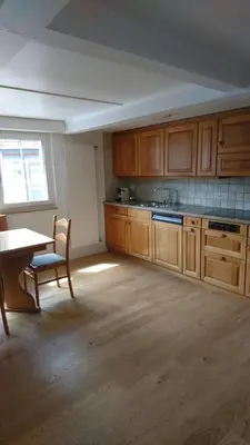 a kitchen with wooden cabinets and a table and a window at Zwinglis Ferienwohnung Klärli in Nesslau