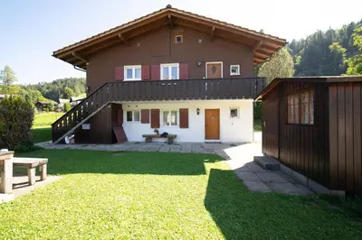 a large house with a fence and a yard at Frühweid in Unterwasser