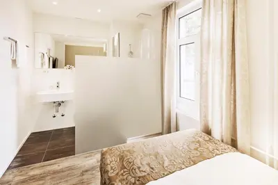 a bedroom with a bed and a sink and a window at Hotel Schäfli in Uzwil