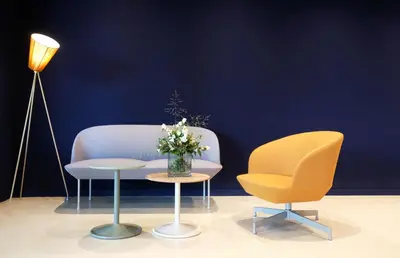 a room with two chairs and a table with a vase of flowers at Hotel Eastside (free parking garage) in St. Gallen