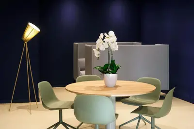 a table and chairs with a vase of flowers on it at Hotel Eastside (free parking garage) in St. Gallen