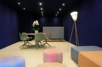 a room with a table and chairs and a lamp at Hotel Eastside (free parking garage) in St. Gallen