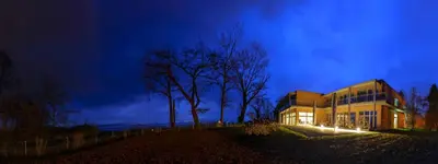 a building with lights in front of it at night at Hotel Restaurant Sokrates in Güttingen