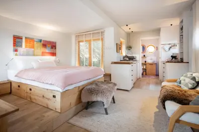a bedroom with a large bed and a kitchen at Logis Freyja in Landschlacht Gemeinde Münsterlingen