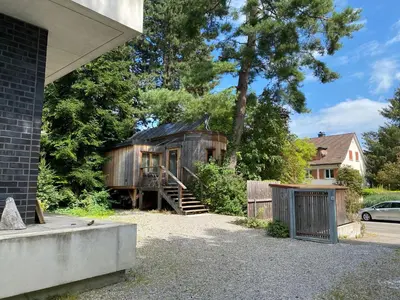 an old wooden house with a porch and a driveway at Logis Freyja in Landschlacht Gemeinde Münsterlingen