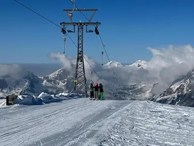 three people standing on a ski lift in the snow at Ferienwohnung Haus am Bach in Toggenburg in Wildhaus