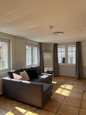 a living room with a couch and some windows at Hotel Untertor by Maier - Self-Check-in in Altstätten