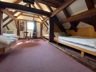a room with two beds and a table and chairs at Hotel Untertor by Maier - Self-Check-in in Altstätten
