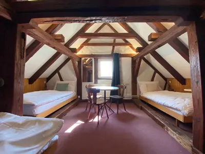 a room with two beds and a table in it at Hotel Untertor by Maier - Self-Check-in in Altstätten