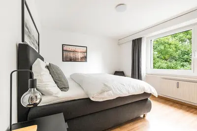 a white bedroom with a bed and a window at SOHO 11 !Gratis Parken, Free Parking! in Kreuzlingen