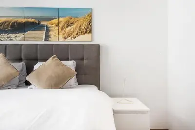 a bedroom with a bed and a picture of a beach at SOHO G !Gratis Parken, Free Parking! in Kreuzlingen