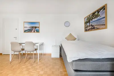 a bedroom with a bed and a table and chairs at SOHO G !Gratis Parken, Free Parking! in Kreuzlingen