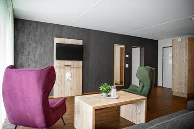 a living room with a couch and a table and chairs at Wohntel - wohnen wie im Hotel in Sevelen